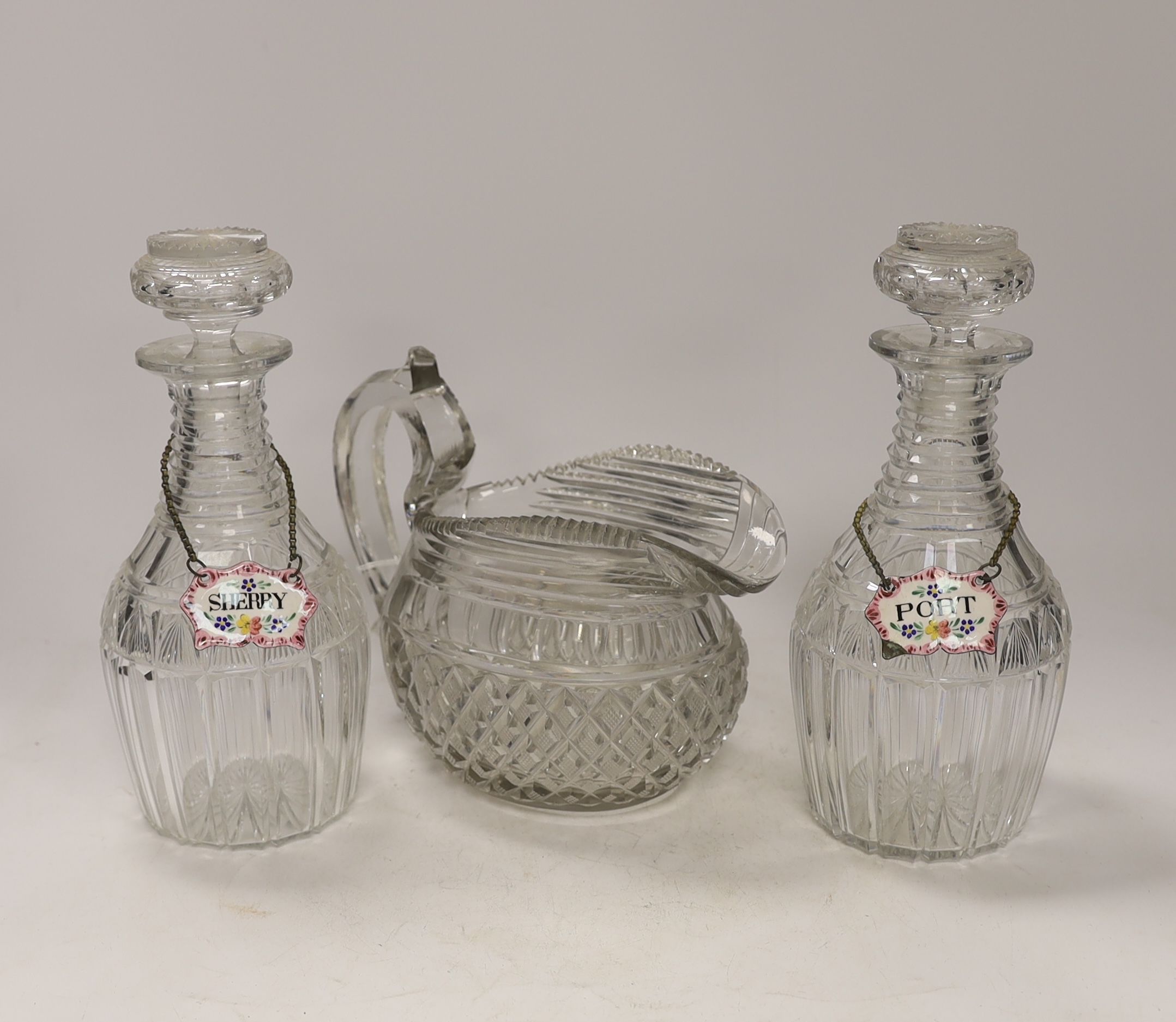 A Regency hobnail and slice cut jug and a pair of Regency cut glass mallet shaped decanters with ‘’Port’’ and ‘’Sherry’’ polychrome enamel labels, 22cm (5)